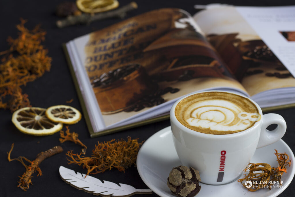 Skodelica kave s knjigo v ozadju