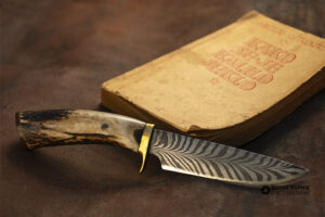 Kovani nož ob knjigi Kako se je kalilo jeklo