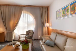 Hotelska soba s stolom, kavčem in sobno lučko